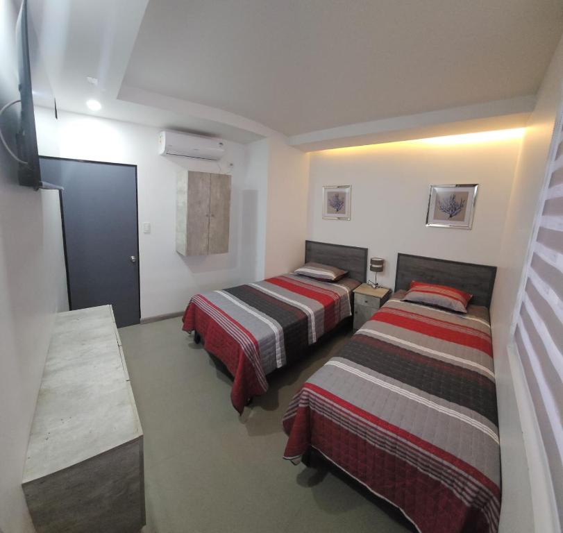 2 camas en una habitación pequeña con 2 camas sidx sidx sidx en Hotel Regata, en Iquique
