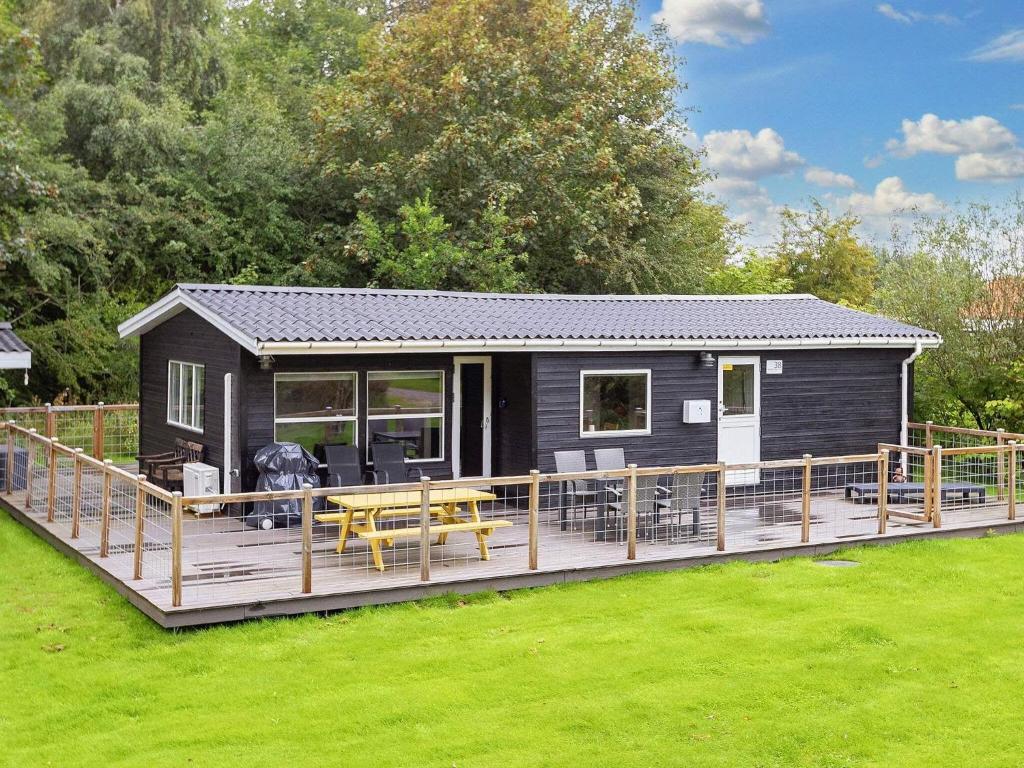 a black tiny house with a large deck at Holiday home Farsø VIII in Farsø