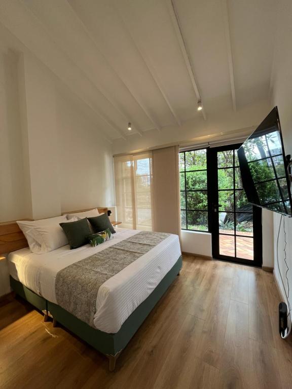 ein Schlafzimmer mit einem großen Bett und einem großen Fenster in der Unterkunft El Diamante Campestre in Medellín
