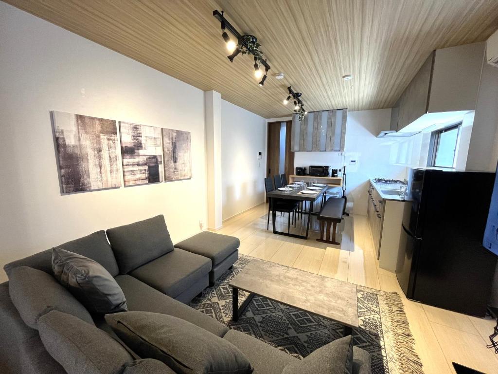un soggiorno con divano e una cucina con tavolo di Naos House Osaka 4 New Open 一軒家貸切 ad Osaka