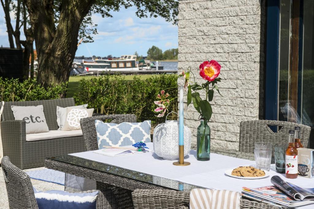 a table with a flower in a vase on a patio at Amsterdam / Loosdrecht Rien van den Broeke Village in Loosdrecht