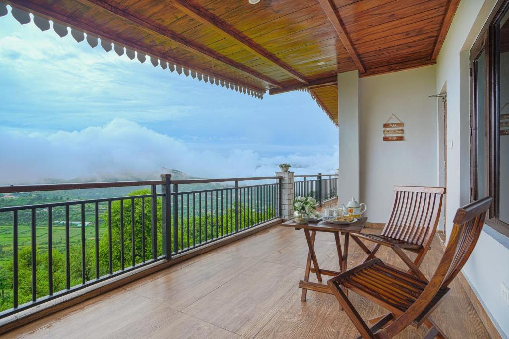 a balcony with a table and a chair and a view at SaffronStays Zephyr in Nainital