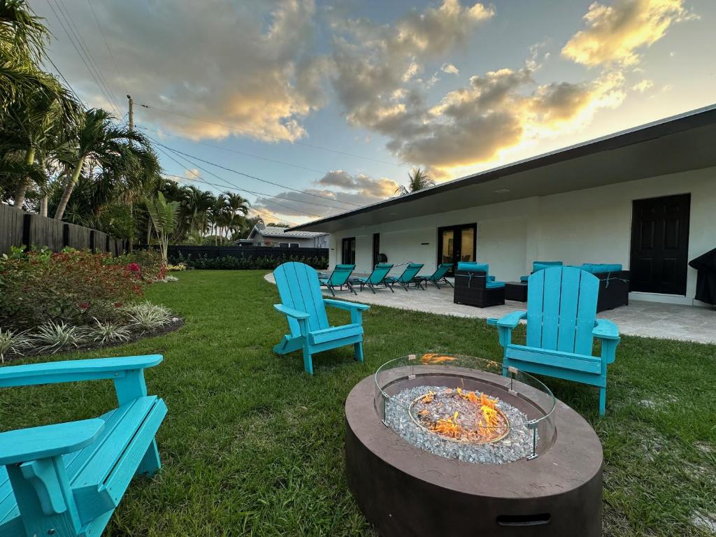 um grupo de cadeiras azuis sentadas à volta de uma fogueira em The Sun House - 3 Bed, 2 Bath, Private Pool, Fire Pit, Huge Backyard em Fort Lauderdale