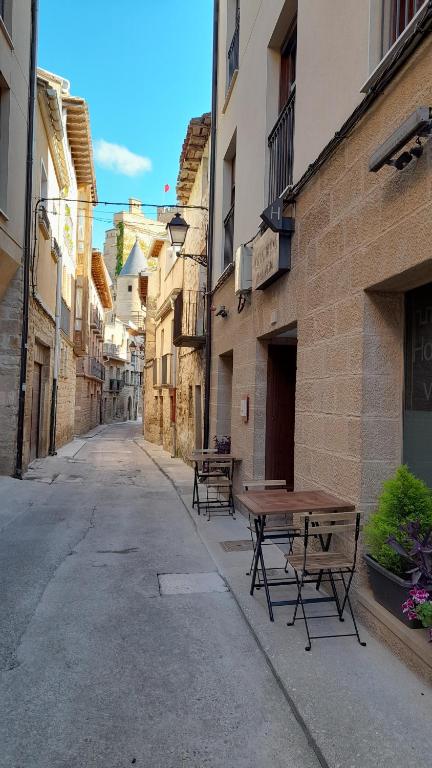 an empty alley with tables and benches on a street at Hostal Rural Villa Vieja in Olite