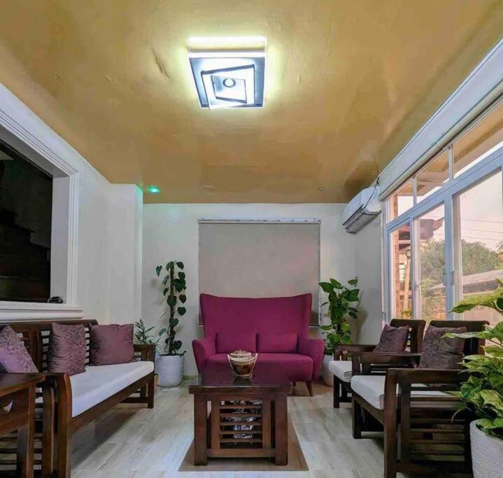 un salon avec un canapé violet et des tables dans l'établissement Discover the charm of this homely villa just a stone's throw from the beach, à Bauang
