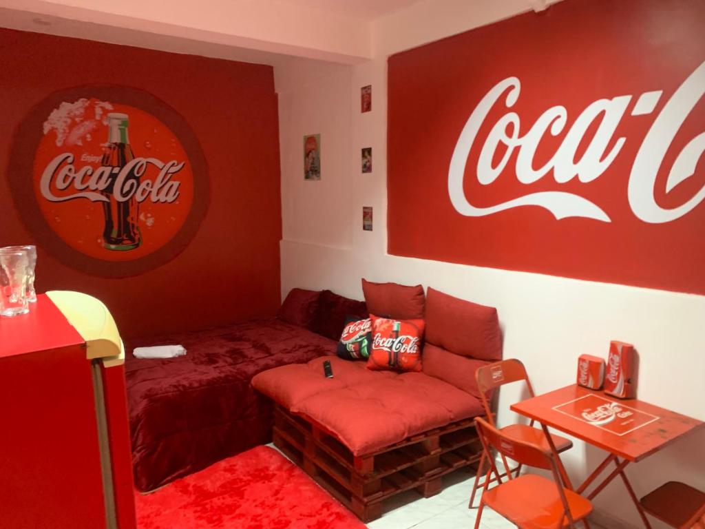 a coca cola room with a couch and a table at Loft Coca-Cola Passo Fundo in Passo Fundo