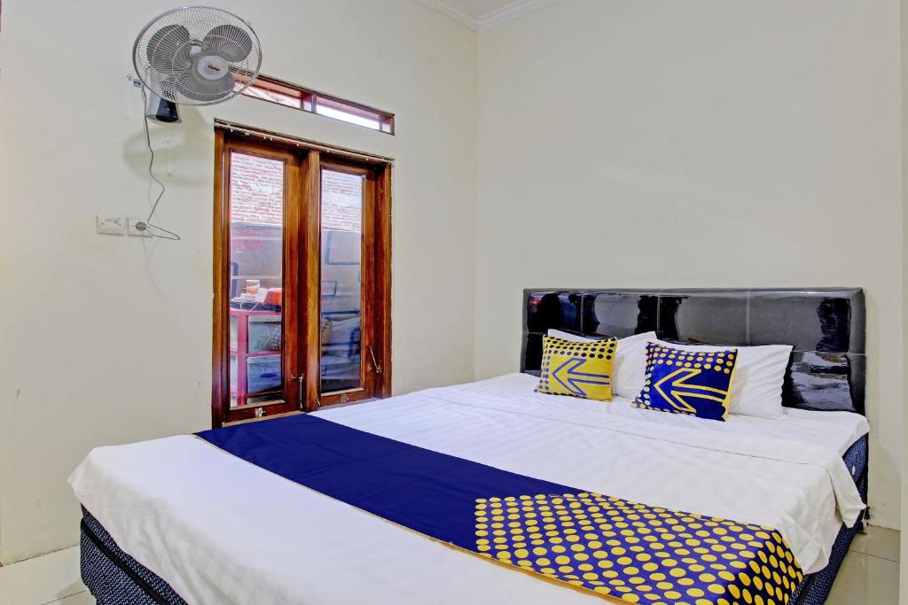 een slaapkamer met 2 bedden en een raam bij SPOT ON 92926 Guest House Cemara 1 Syariah in Brebes