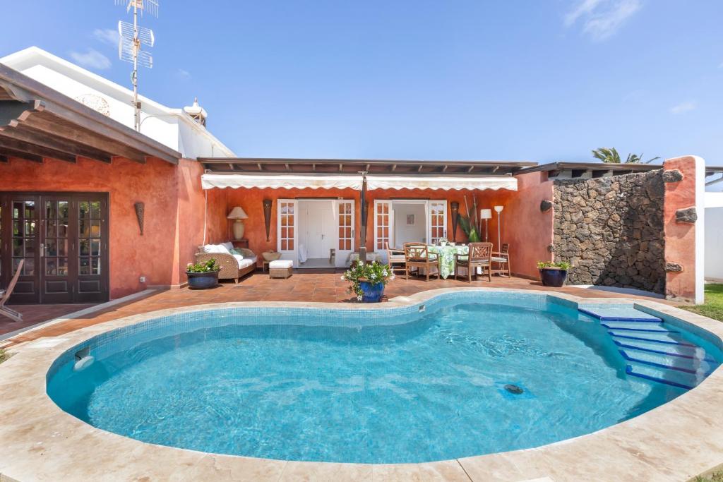 uma piscina no quintal de uma casa em Evergreen Villa em Costa Teguise