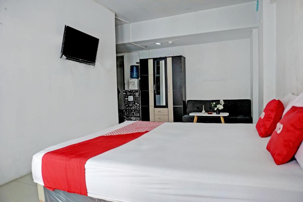 a bedroom with a large white bed with red pillows at Collection O 92959 Apartement Sentraland Karawang By AT Room in Karawang