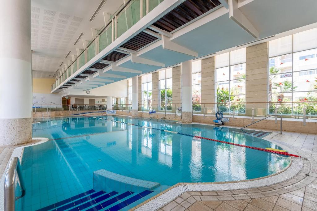 une grande piscine intérieure d'eau bleue dans l'établissement Awesome 2BR/2Bath with Pool and Gym, à Herzliya