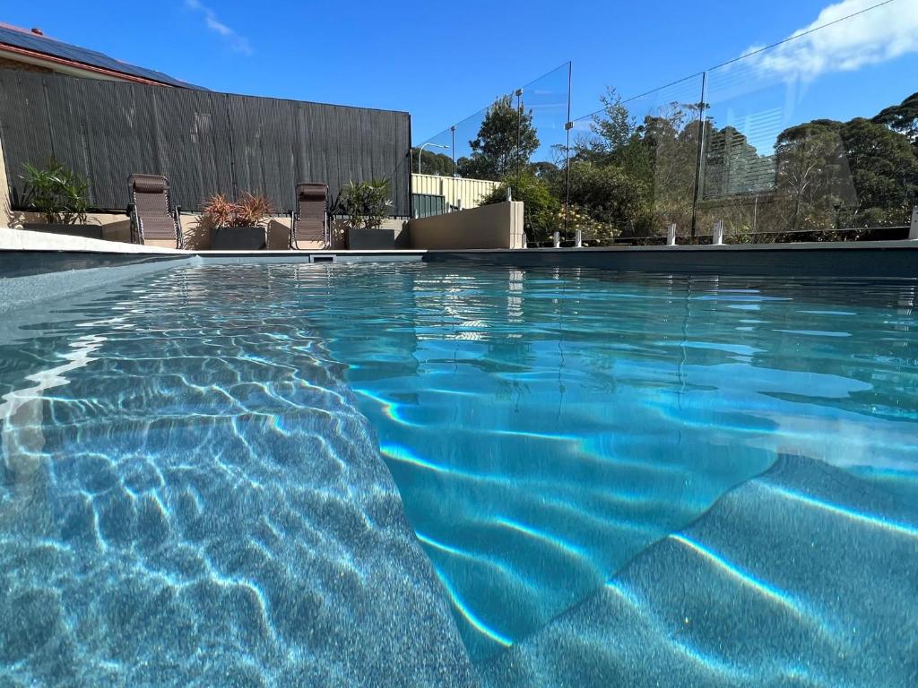 een zwembad met blauw water bij Kookaburra Heights in Mollymook