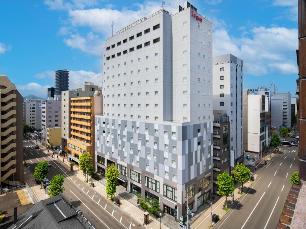 um edifício branco alto numa rua da cidade em La'gent Stay Sapporo Odori Hokkaido em Sapporo