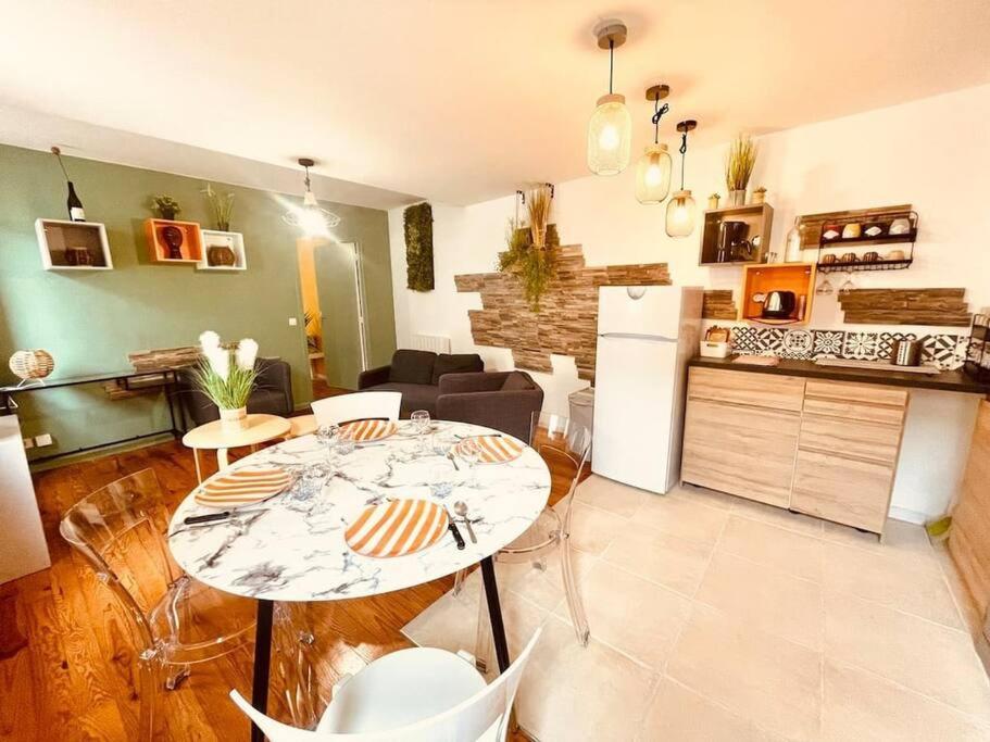 a kitchen and a living room with a table and chairs at L'edelweiss: three-bedroom hypercentre in Saint-Étienne