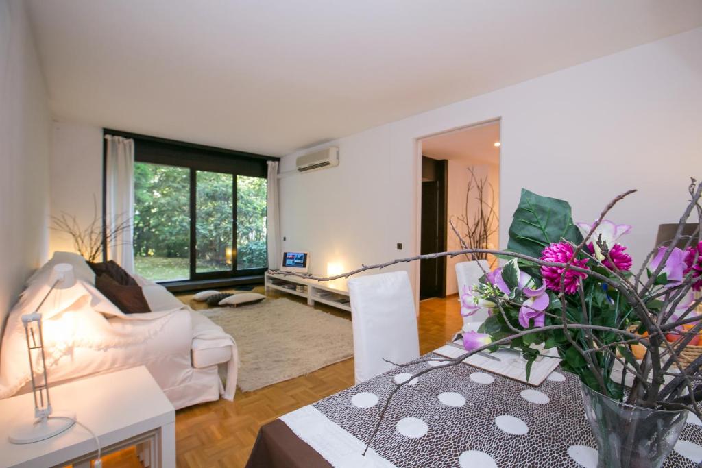 a living room with a couch and a table with flowers at Lugano Luxury - Happy Rentals in Lugano