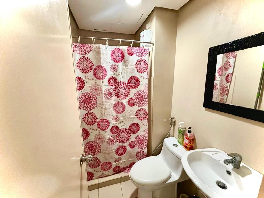 a bathroom with a toilet and a shower curtain at Affordable Ayala Avida IT Park Condo across Ayala Mall Central Bloc Sugbu Mercado in Tabok