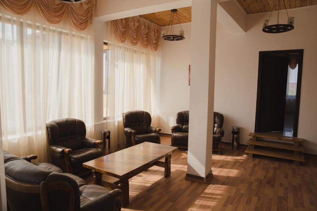 a waiting room with leather chairs and a table at Casa Rustica in Focşani