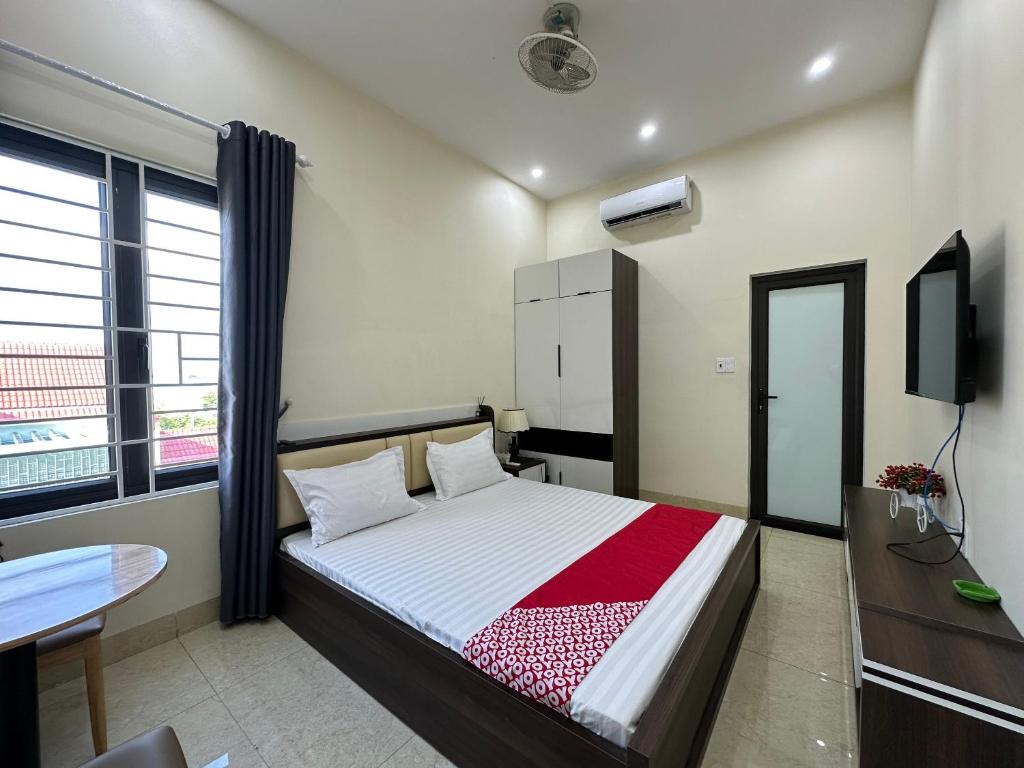 um quarto com uma cama, uma secretária e uma televisão em OYO 1199 Dung Quyen Hotel em Da Nang