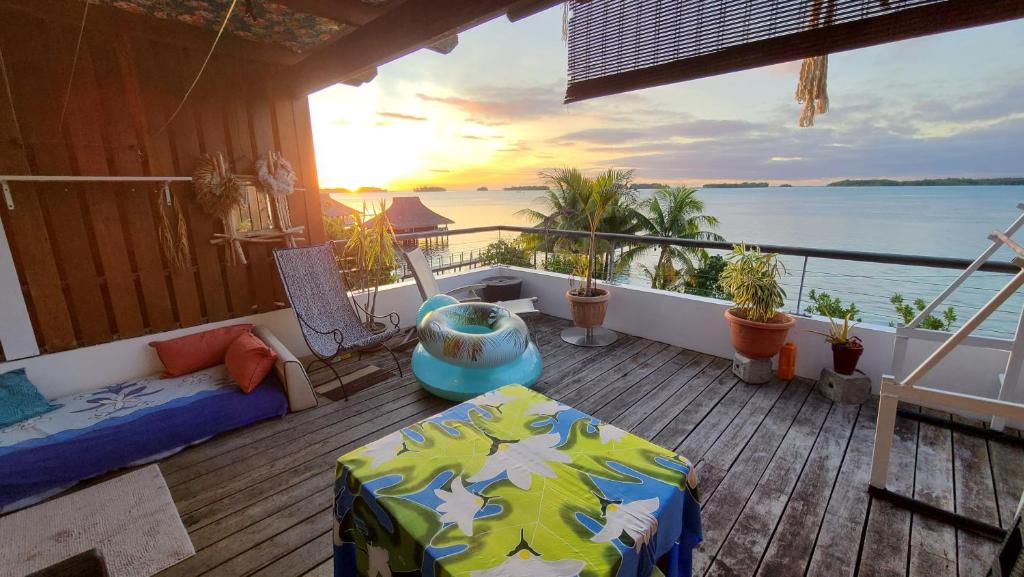 a balcony of a house with a bed and a view of the ocean at L'Horizon in Bora Bora