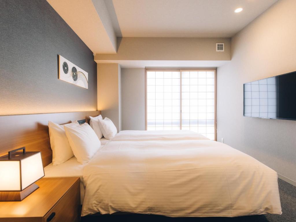 Postel nebo postele na pokoji v ubytování MIMARU SUITES Kyoto Shijo