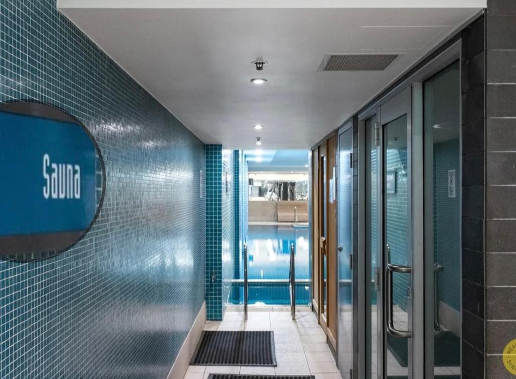 a hallway of a bathroom with blue tiles at Absolute Beachfront at the Pier Glenelg in Glenelg