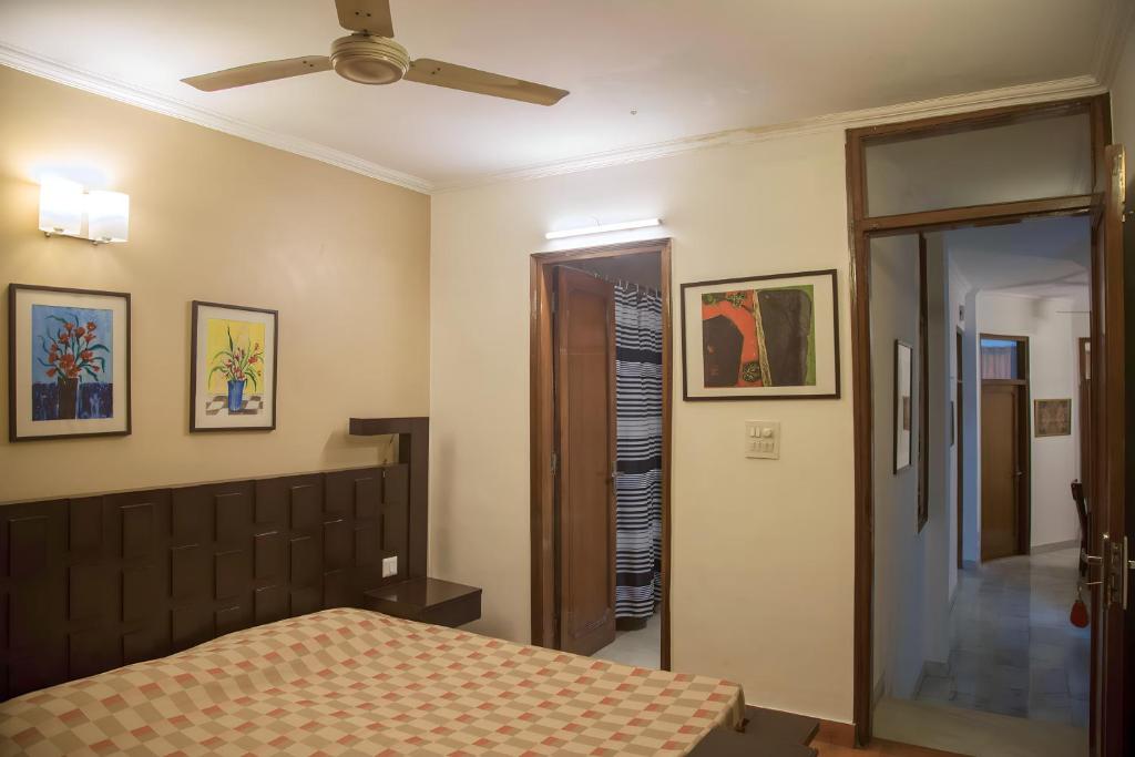 a bedroom with a bed and a ceiling fan at Woodpecker Apartments Hauz khas in New Delhi