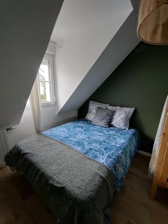 a bed in a room with a green wall at Appartement NATURA 2 chambres in Vitré