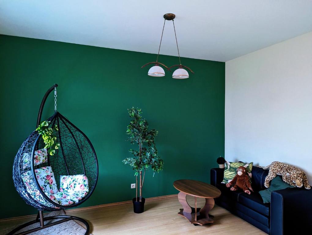 un soggiorno con pareti verdi e un divano nero di Little Cozy Place a Sigulda