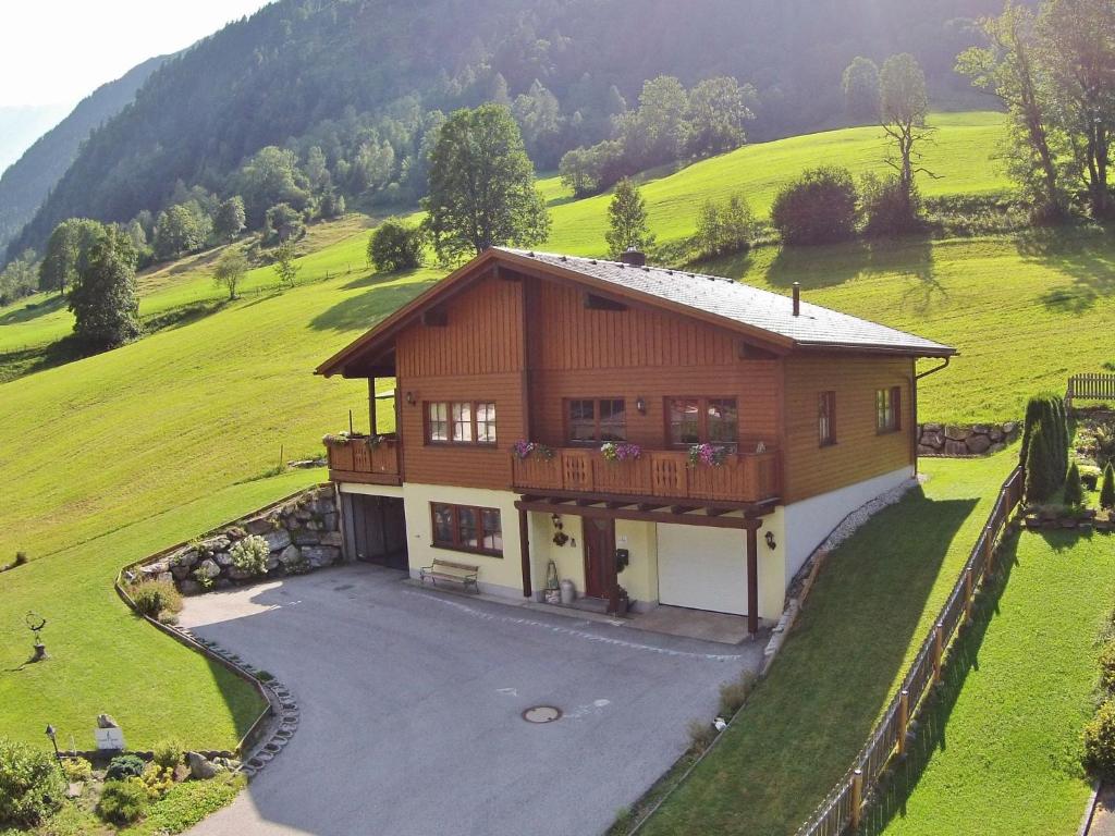 a large house in a field with a yard at Luxury chalet in Fusch an der Grossglocknerstrasse Salzburgerland with sauna in Fusch an der Glocknerstraße