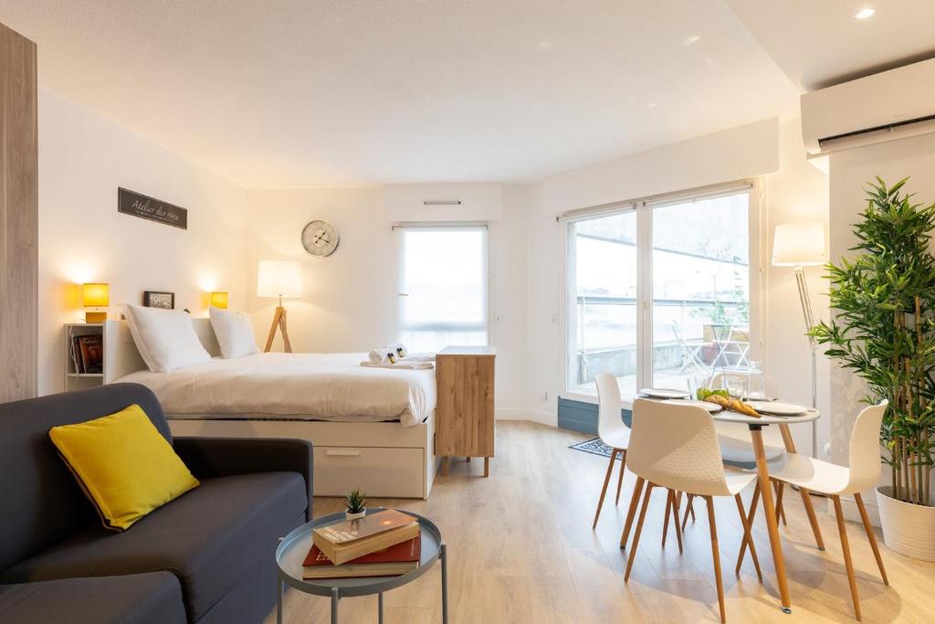 ein Schlafzimmer mit einem Bett und ein Wohnzimmer in der Unterkunft GuestReady - Nice Studio with Terrace in Lyon