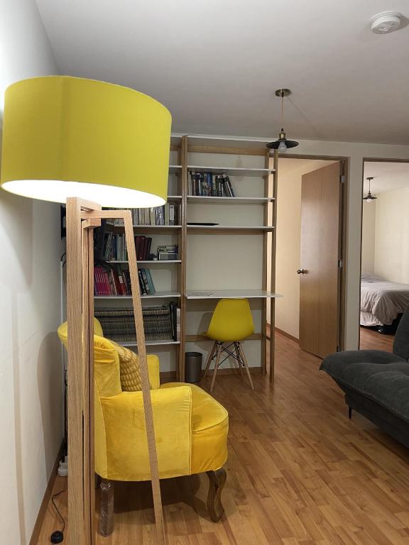Hotel Departamento en Centro Ciudad de México Alameda Reforma, a yellow chair in a living room with a lamp at Departamento en Centro Ciudad de México Alameda Reforma in Mexico City