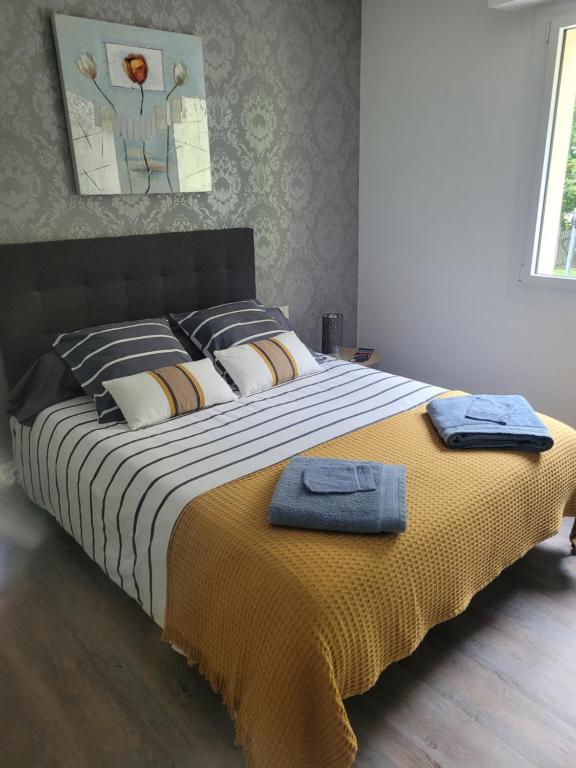 a bedroom with a large bed with two towels on it at Campagne à la Ville in Pontivy