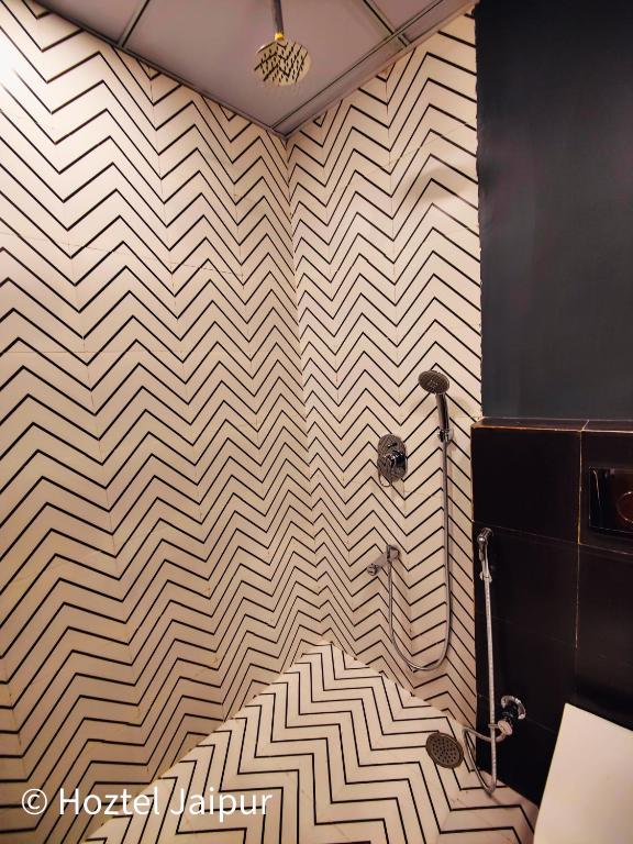a bathroom with aige and white chevron wall at Hoztel Jaipur in Jaipur