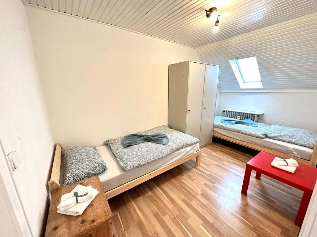 een kamer met twee bedden en een tafel erin bij Spacious & Cozy Apartments in Krefeld