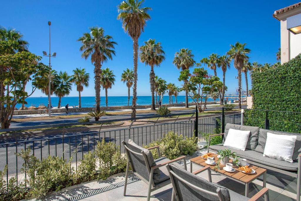 d'une terrasse avec une table et des chaises et une vue sur la plage. dans l'établissement Malagueta Beach Front Luxury Apartment by Rent Me, à Malaga