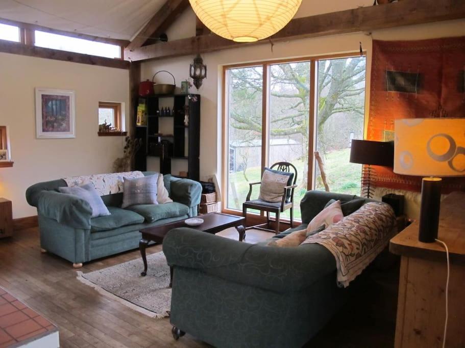 Beautiful Award-Winning Rural Home في Dolphinton: غرفة معيشة بها كنبتين ونافذة كبيرة