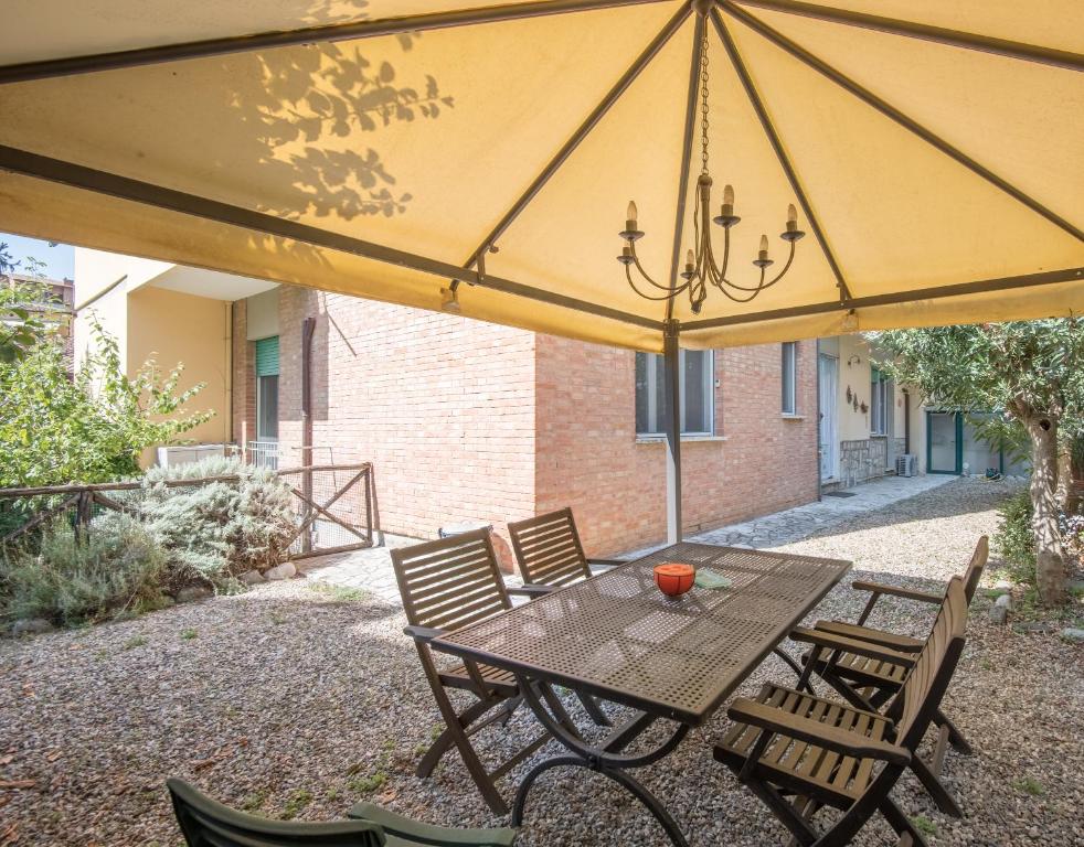 einen Tisch und Stühle unter einem großen gelben Schirm in der Unterkunft Dimora di Sofia in Siena