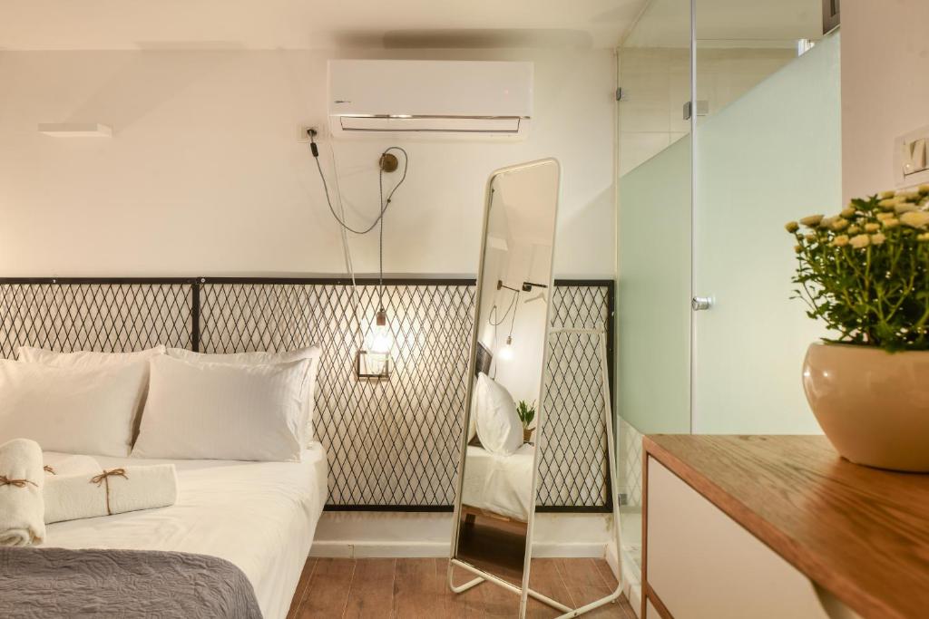 um quarto com uma cama e um espelho em The Carmel House - Aparthotel in Kerem Hateimanim By Sea N' Rent em Tel Aviv