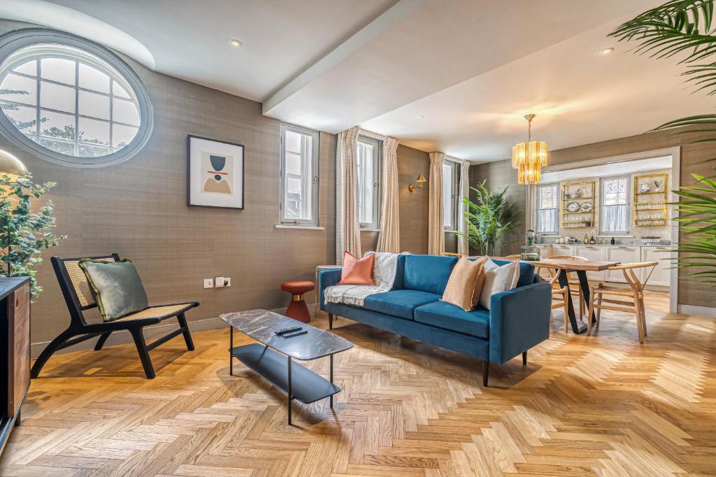 a living room with a blue couch and a table at Luxury flats near Big Ben and London Eye in London