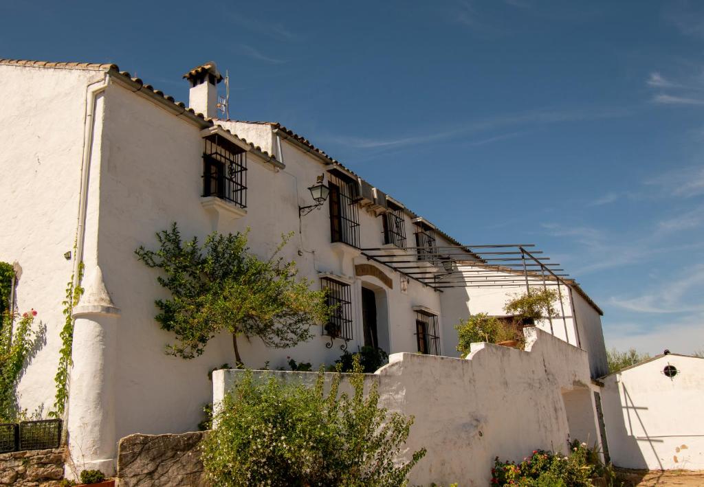 uma casa branca com uma cerca à frente. em Casa rural el Carmen em Prado del Rey