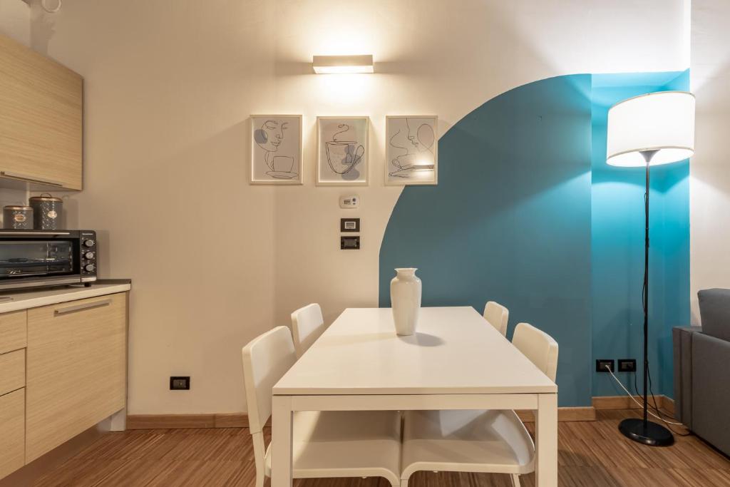 a dining room with a white table and chairs at Corte D'Appello Houses in Turin