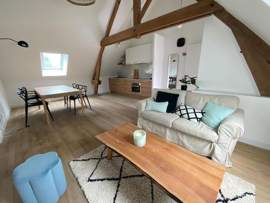 a living room with a couch and a table at Domaine de La Quenouille - Appartement B in Péronne