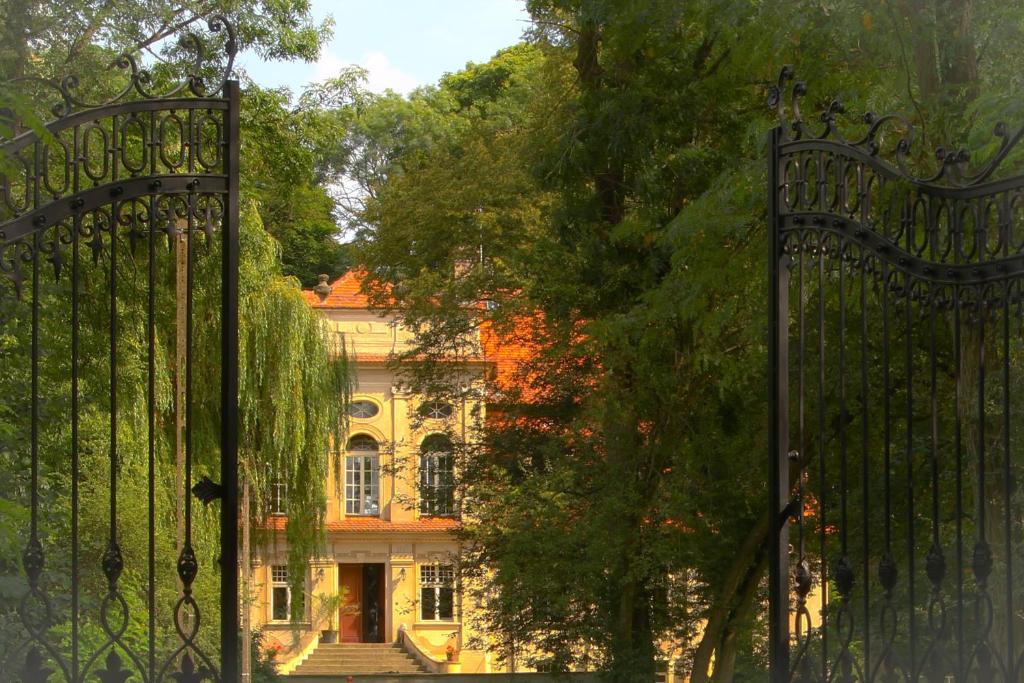 um portão em frente a uma casa com árvores em Palace Popowo Stare em Stare Popowo