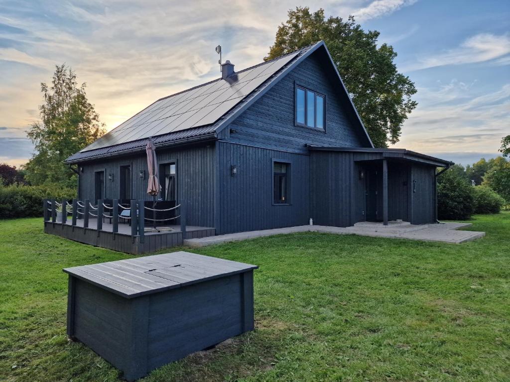 a black house with a large yard in front of it at Family holiday house near to Baltic sea in Pitrags "JAUNZUMBRI" in Pitragutsiyeme