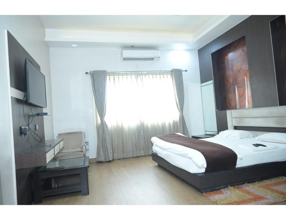 sypialnia z dużym łóżkiem i oknem w obiekcie Hotel The Park, Muzaffarpur w mieście Muzaffarpur