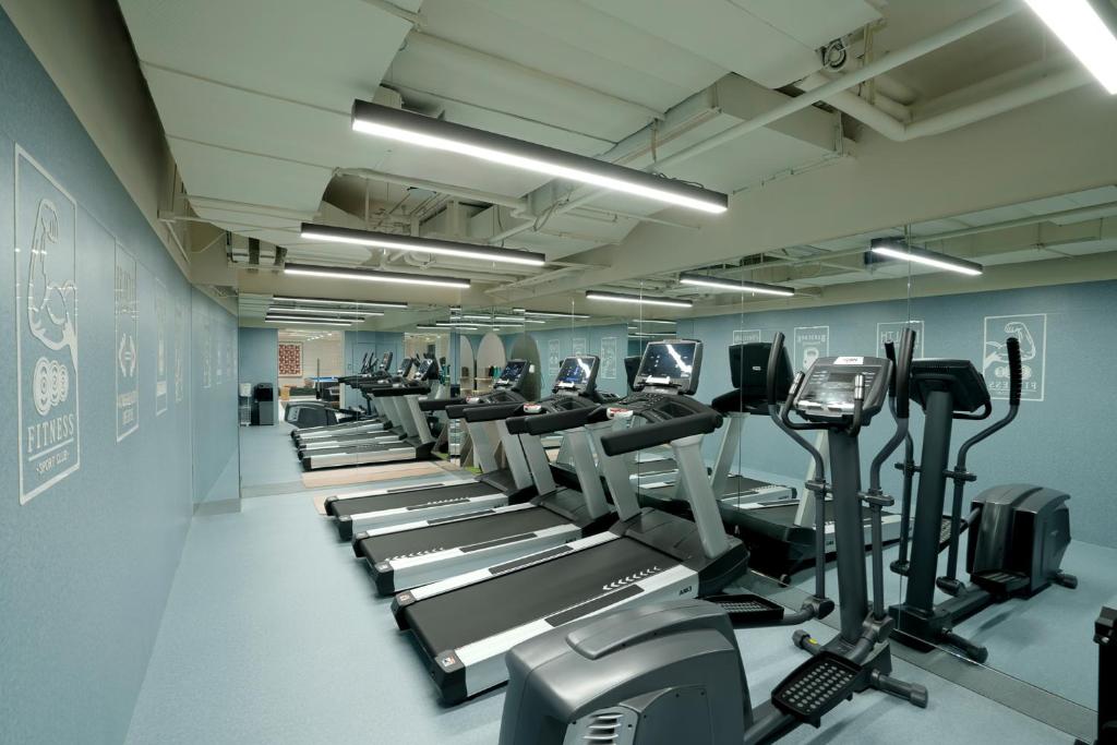 a gym with a row of treadms and machines at base-Beijing Wangfujing Serviced Apartment- in Hutong &Bike rental &Close to Forbidden City, Tian'anmen Square &Subway nearby &Free coffee &Washing machine,Kitchen &Restaurant discount &English speaking &High speed free WiFi in Beijing