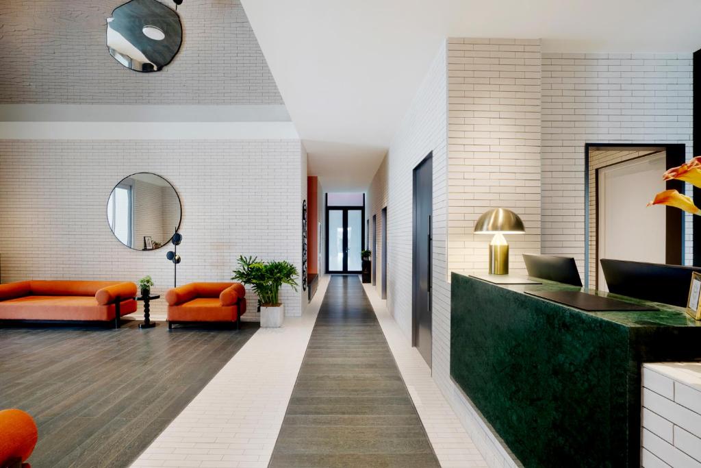 a lobby with orange furniture and a mirror at base-Beijing Wangfujing Serviced Apartment- in Hutong &Bike rental &Close to Forbidden City, Tian'anmen Square &Subway nearby &Free coffee &Washing machine,Kitchen &Restaurant discount &English speaking &High speed free WiFi in Beijing