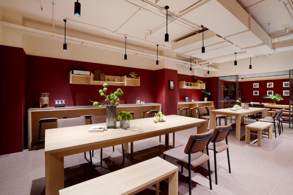 a restaurant with tables and chairs and red walls at base-Beijing Wangfujing Serviced Apartment- in Hutong &Bike rental &Close to Forbidden City, Tian'anmen Square &Subway nearby &Free coffee &Washing machine,Kitchen &Restaurant discount &English speaking &High speed free WiFi in Beijing