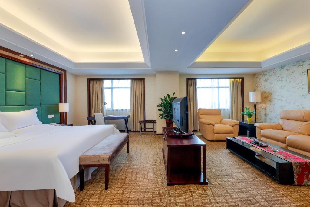 a bedroom with a large bed and a living room at Zhengzhou Yuehai Hotel in Zhengzhou