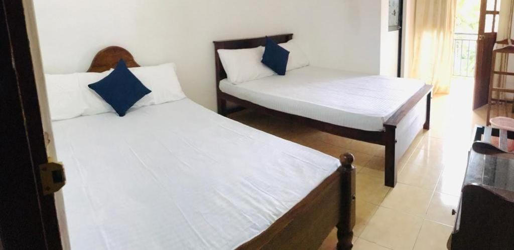 a bedroom with two beds and a couch in it at Sunila Family Rest Anuradhapura in Anuradhapura