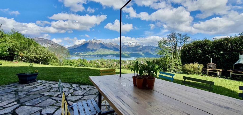 a wooden table with a view of a lake and mountains at Les Eaux Vives in Sévrier